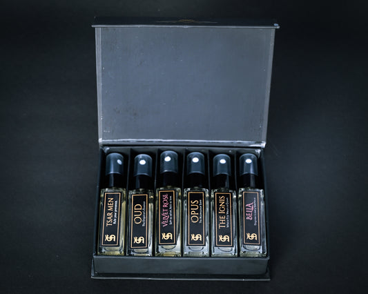 Set of perfume bottles in a display case on a black background