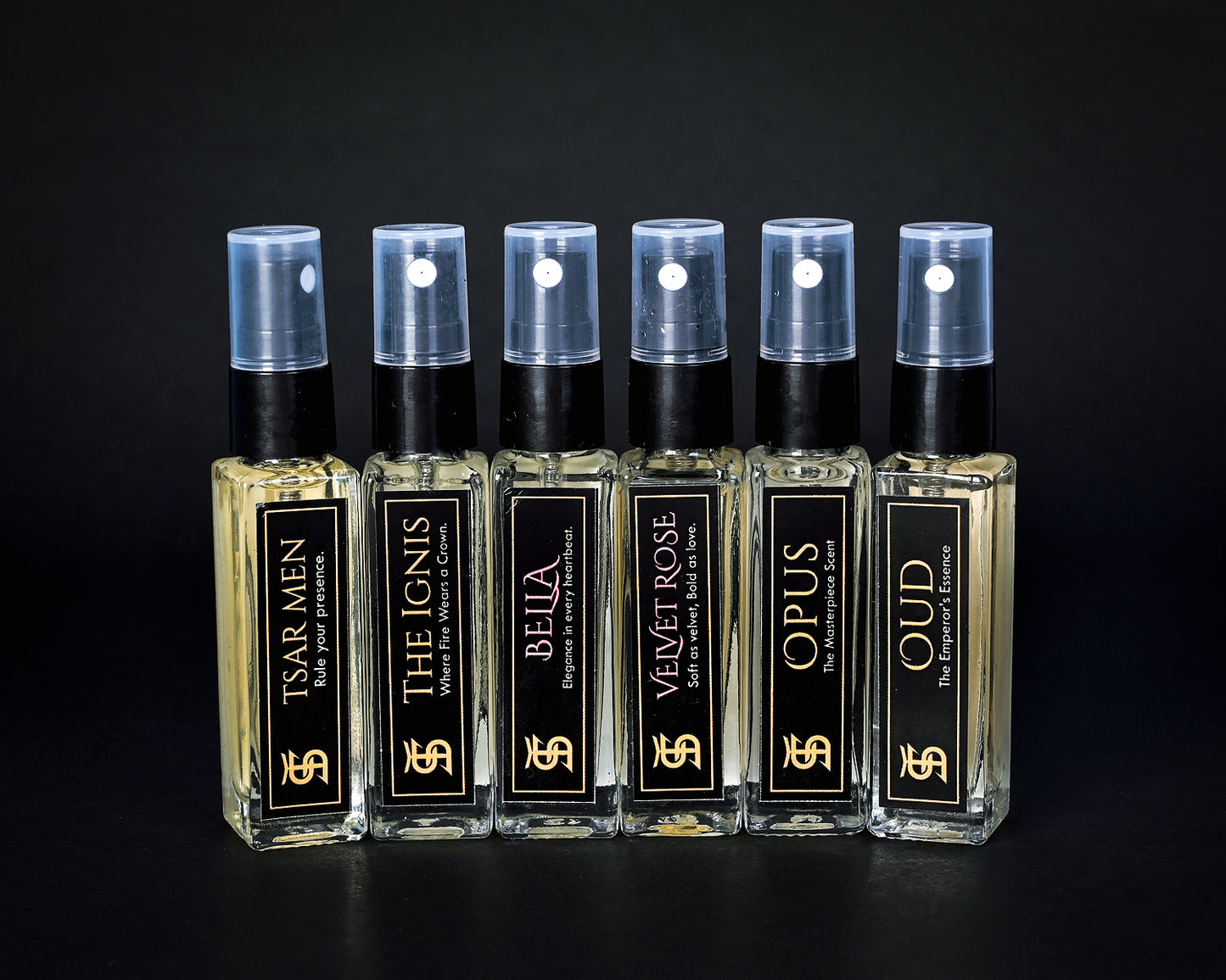 Set of perfume bottles with black and gold labels on a dark background