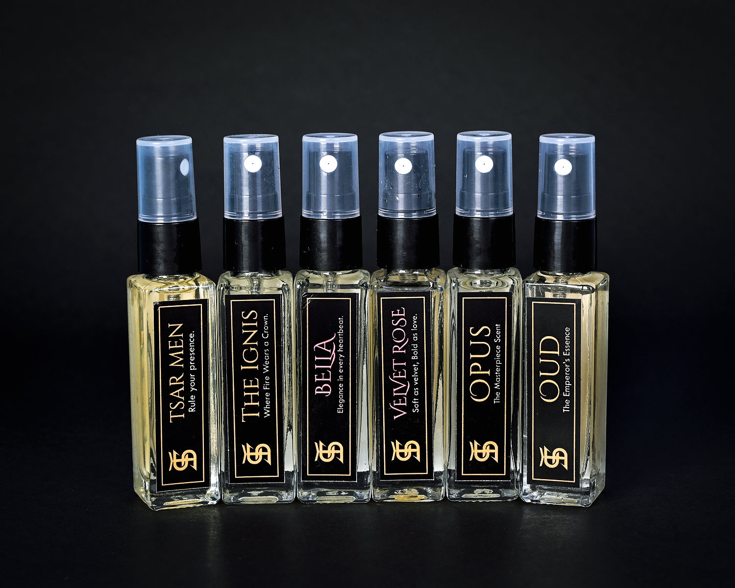 Set of perfume bottles with black and gold labels on a dark background